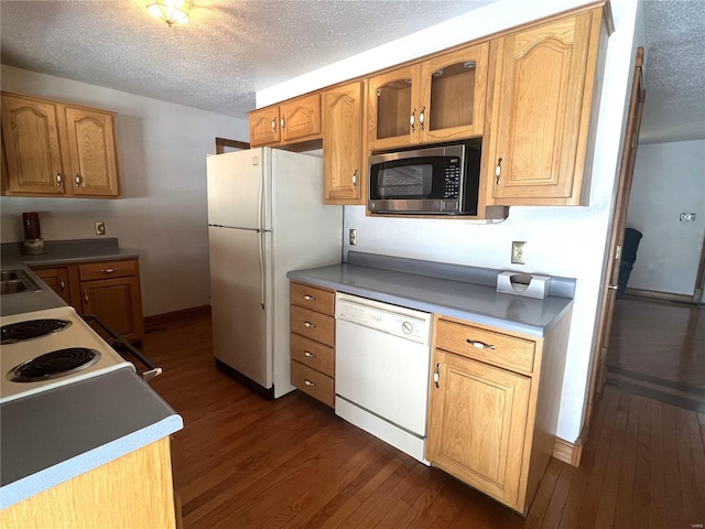 kitchen featuring glass insert cabinets, white appliances, dark wood finished floors, and a textured ceiling