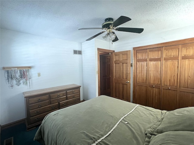 bedroom featuring ceiling fan, a closet, visible vents, and a textured ceiling