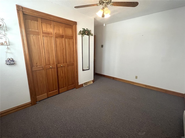 unfurnished bedroom with baseboards, ceiling fan, carpet, a textured ceiling, and a closet