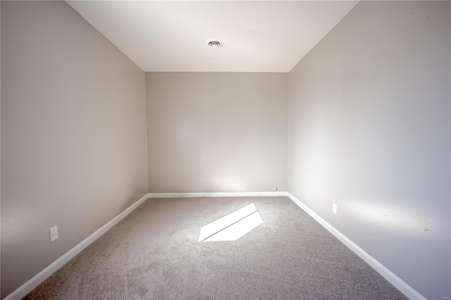 unfurnished room featuring carpet flooring, visible vents, and baseboards