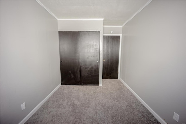 interior space with baseboards, a closet, carpet flooring, and crown molding