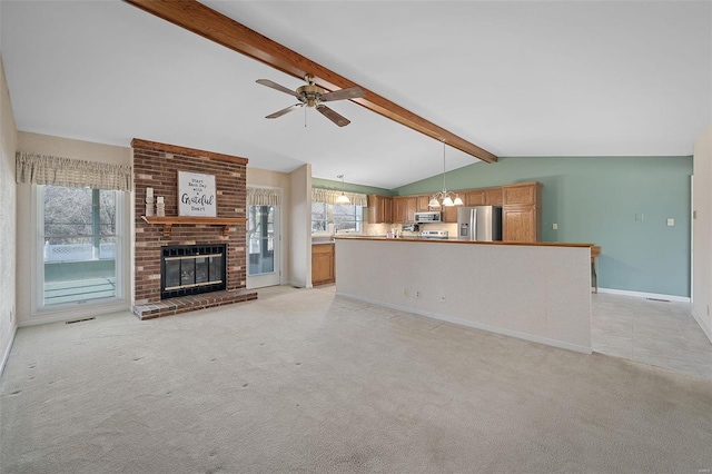 unfurnished living room with light carpet, a fireplace, vaulted ceiling with beams, and ceiling fan with notable chandelier