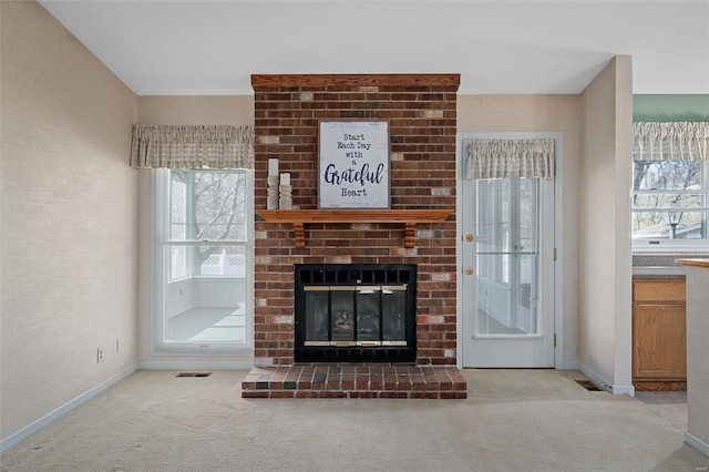 unfurnished living room featuring visible vents, a brick fireplace, baseboards, and carpet floors