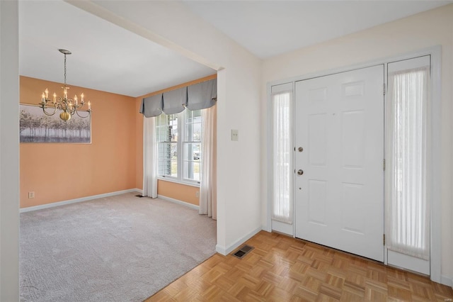 entrance foyer featuring visible vents, baseboards, and an inviting chandelier