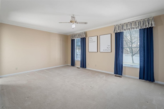 spare room with a wealth of natural light, visible vents, carpet, and ornamental molding