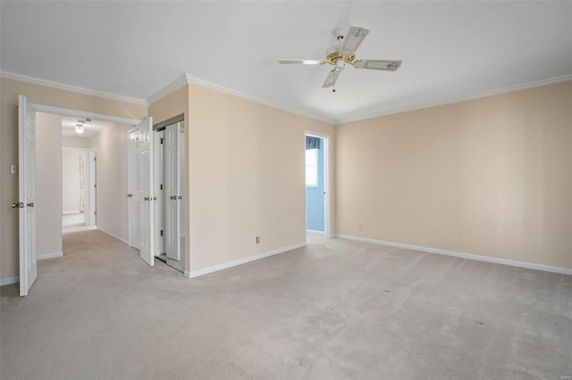 unfurnished room with crown molding, light colored carpet, and baseboards