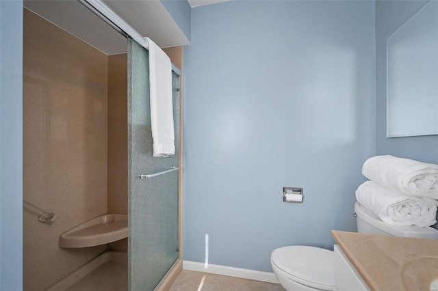 bathroom featuring tile patterned flooring, a shower stall, baseboards, toilet, and vanity