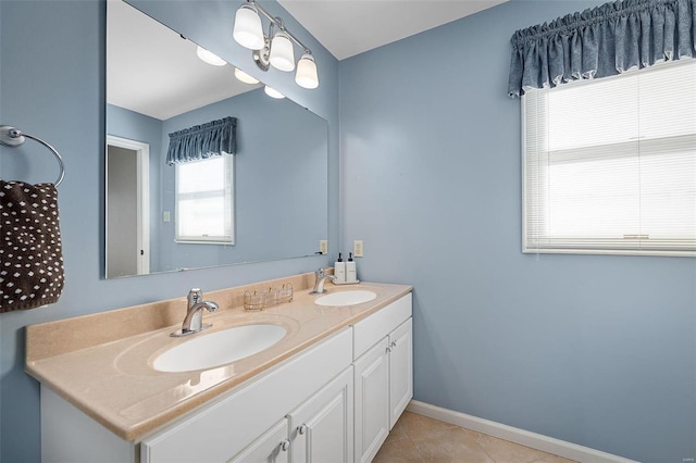 full bath featuring tile patterned flooring, double vanity, baseboards, and a sink