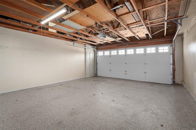 garage with a garage door opener and baseboards