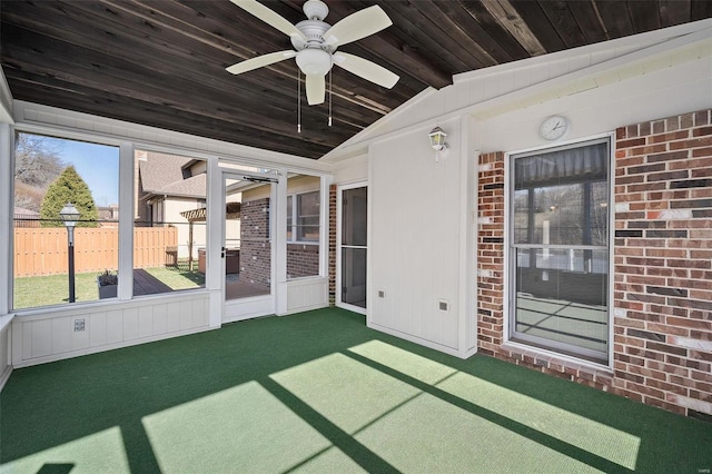 unfurnished sunroom with a ceiling fan, vaulted ceiling with beams, and wood ceiling