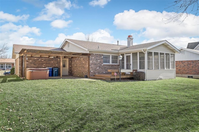 back of house featuring brick siding, a chimney, a sunroom, and a hot tub