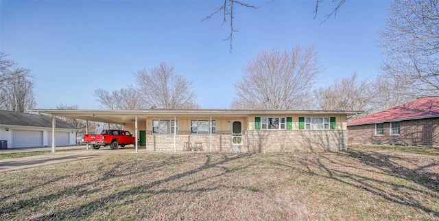 view of front facade with brick siding, an attached carport, driveway, and a front yard