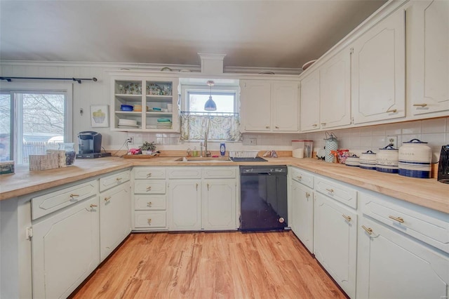 kitchen featuring light wood-type flooring, black dishwasher, decorative backsplash, white cabinets, and a sink