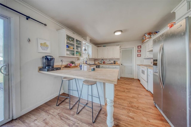 kitchen with light countertops, a peninsula, white range, light wood-style floors, and stainless steel refrigerator with ice dispenser