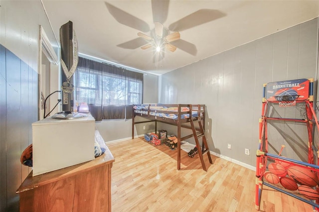 bedroom featuring a ceiling fan, baseboards, and wood finished floors