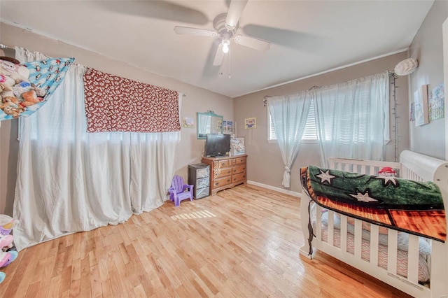 bedroom with a ceiling fan, wood finished floors, and baseboards