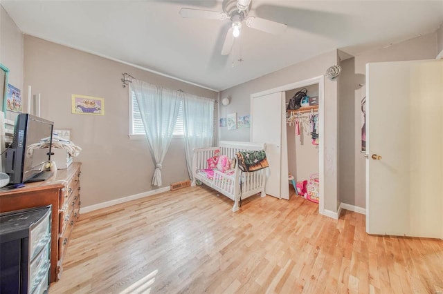 bedroom with visible vents, a ceiling fan, wood finished floors, a closet, and baseboards