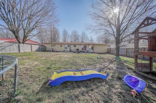 back of house with a lawn and a fenced backyard