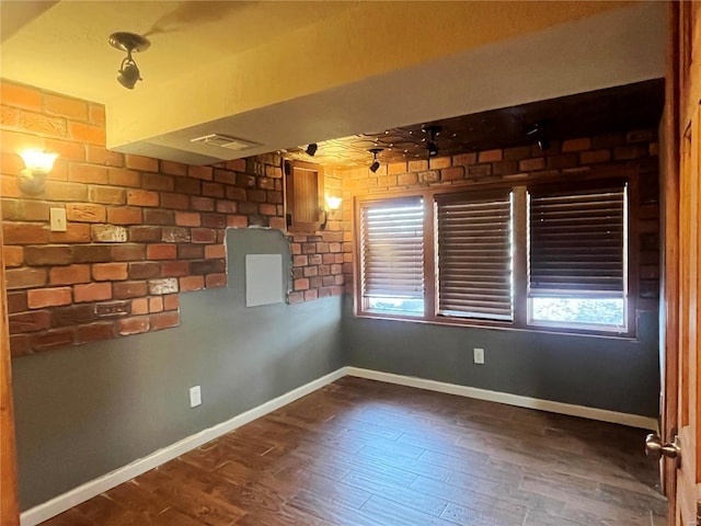 empty room with a healthy amount of sunlight, dark wood-style floors, and baseboards