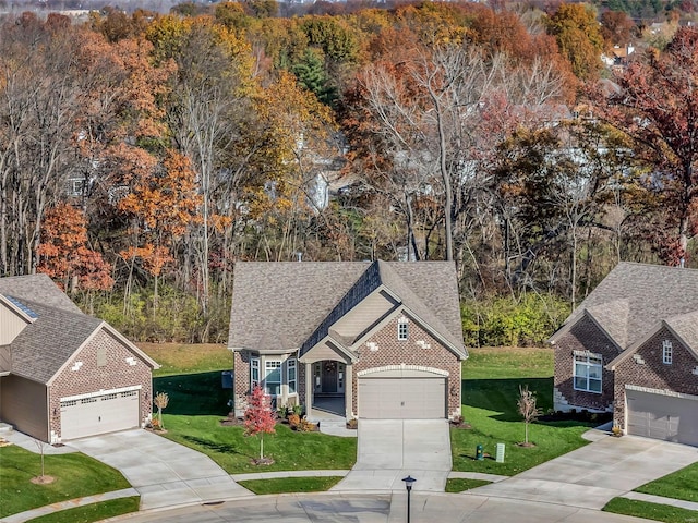 view of front facade featuring a forest view, a front lawn, and brick siding