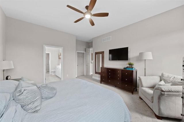 bedroom featuring light carpet, ensuite bath, visible vents, and a ceiling fan