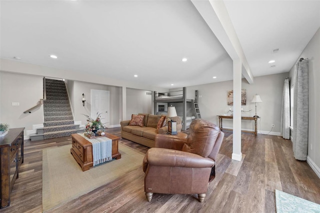 living area featuring baseboards, stairway, wood finished floors, and recessed lighting