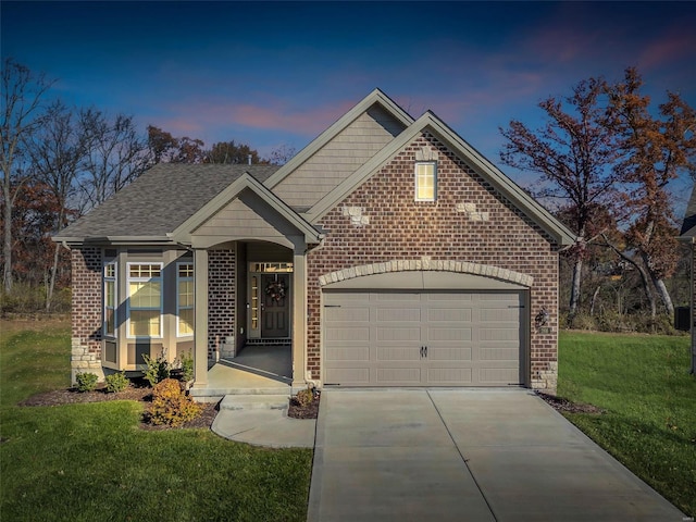 view of front of house featuring an attached garage, a front lawn, concrete driveway, and brick siding