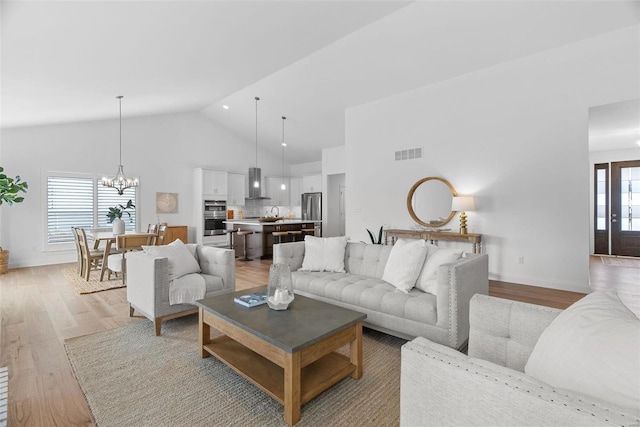 living room with a chandelier, visible vents, high vaulted ceiling, light wood-type flooring, and baseboards