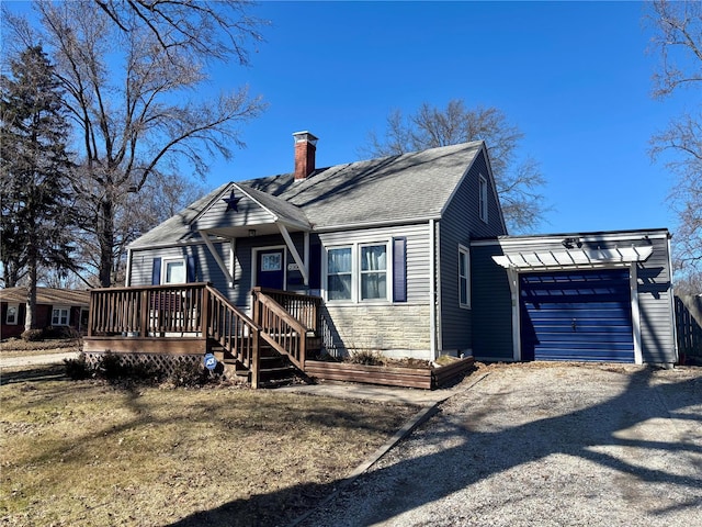 view of front of home featuring gravel driveway, roof with shingles, a chimney, a deck, and a garage