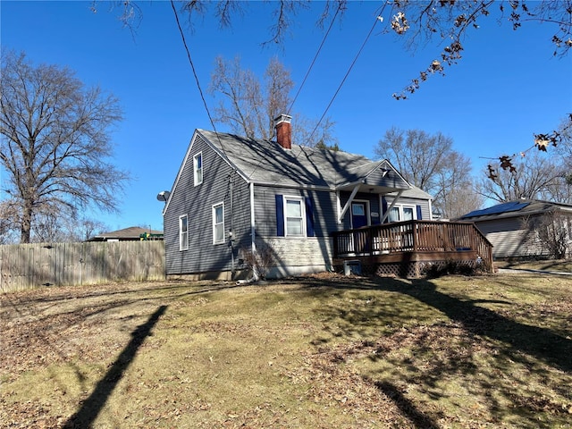 back of house with a yard, a chimney, fence, and a wooden deck