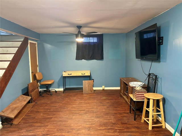 living area with a ceiling fan, wood finished floors, baseboards, and stairs