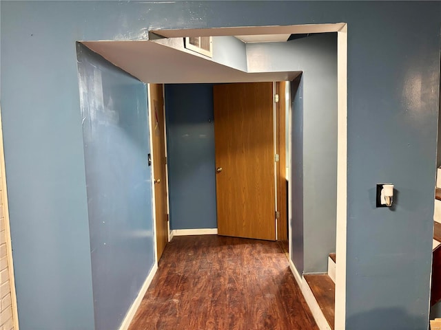 hallway featuring wood finished floors and baseboards