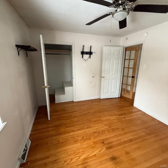 unfurnished bedroom featuring baseboards, a closet, visible vents, and light wood-style floors