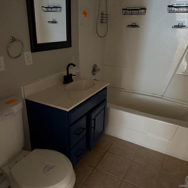 bathroom featuring tile patterned flooring, vanity, toilet, and shower / bathtub combination