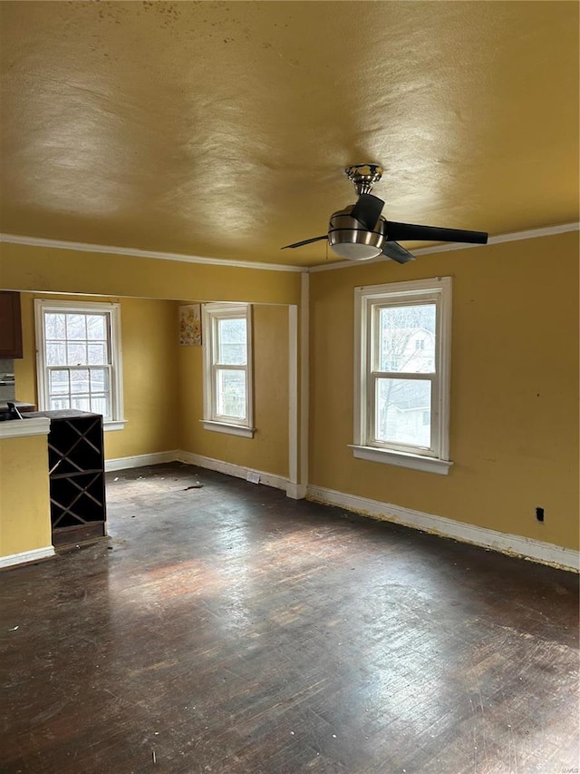 unfurnished living room with ceiling fan, crown molding, baseboards, and a textured ceiling