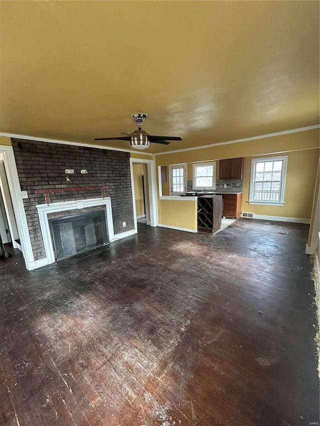 unfurnished living room with dark wood finished floors, visible vents, a brick fireplace, ceiling fan, and baseboards