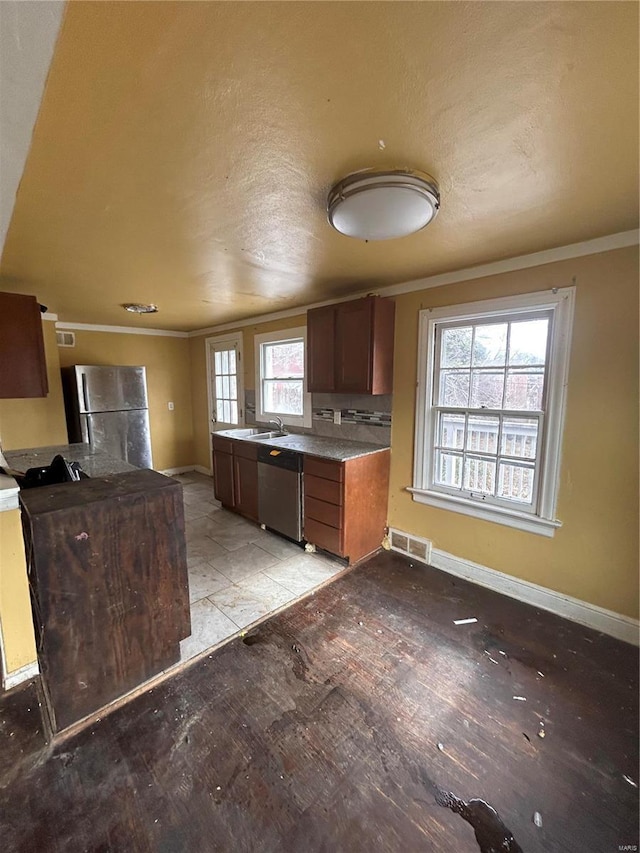 kitchen featuring visible vents, appliances with stainless steel finishes, baseboards, and ornamental molding