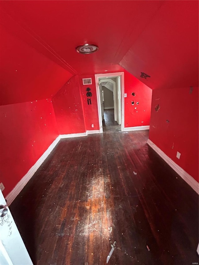 bonus room with lofted ceiling, hardwood / wood-style flooring, baseboards, and visible vents