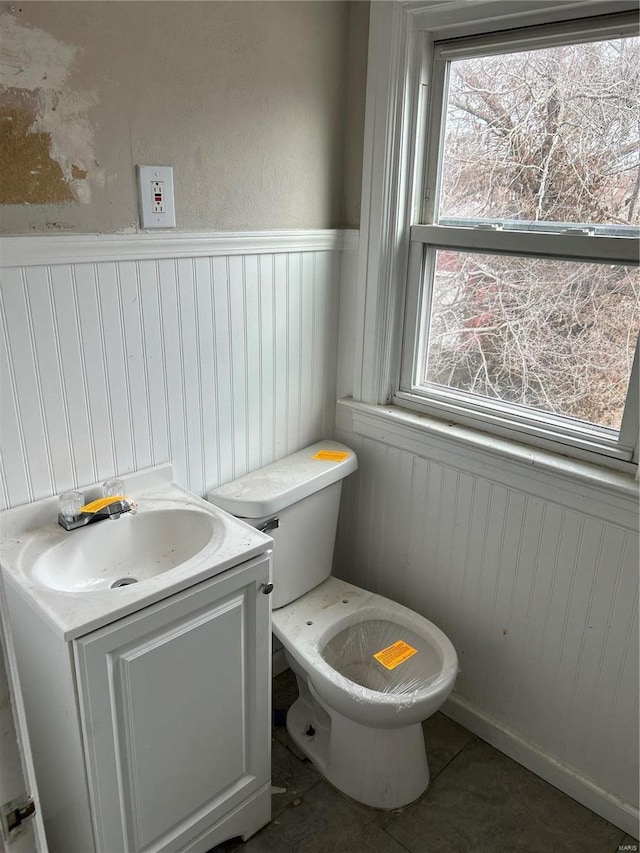 half bath featuring wainscoting, vanity, and toilet