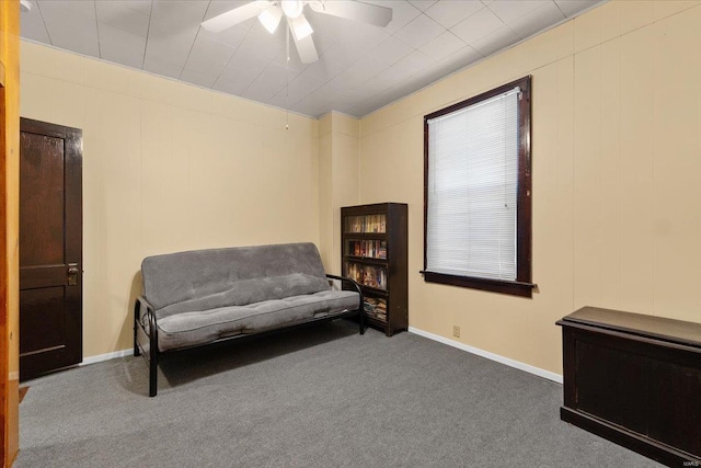 living area featuring ceiling fan, carpet floors, and baseboards