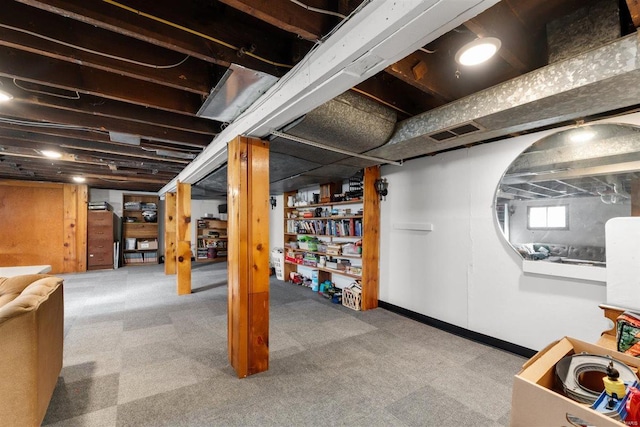 basement featuring baseboards, visible vents, and carpet flooring