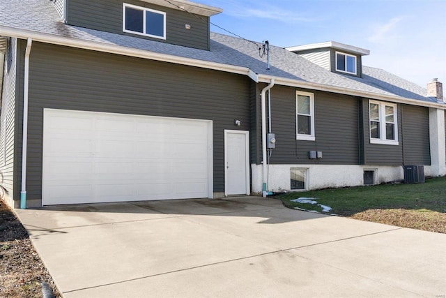 view of front facade featuring a garage, a shingled roof, driveway, and a front lawn