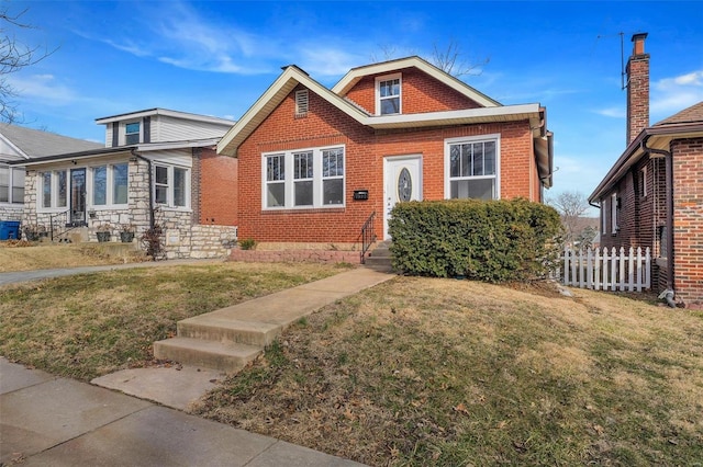 bungalow-style home featuring brick siding, a front yard, and fence