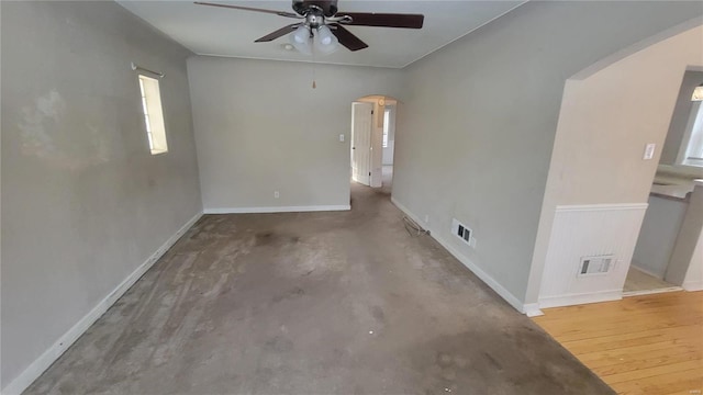 spare room featuring ceiling fan, baseboards, visible vents, and arched walkways