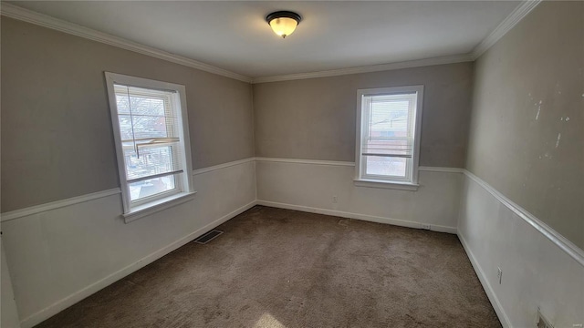 empty room featuring ornamental molding, carpet, visible vents, and baseboards