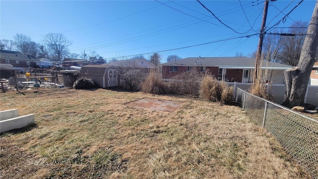 view of yard featuring fence, an outdoor structure, and a storage shed