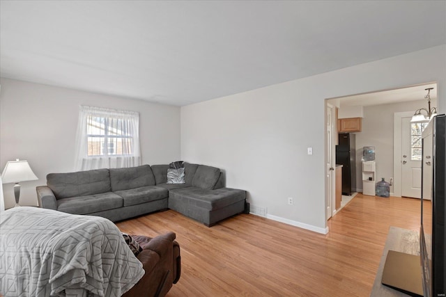 living area featuring light wood-style floors and baseboards