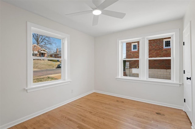 spare room featuring baseboards, a ceiling fan, and light wood finished floors