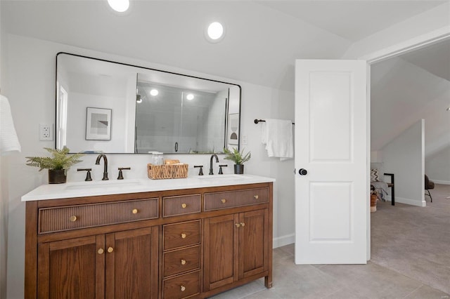 bathroom with a sink, baseboards, a stall shower, and double vanity