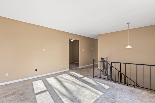 carpeted spare room featuring baseboards